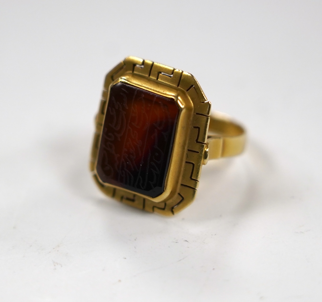 A 14k and carnelian set ring, with pierced border and stone inscribed with Islamic script, size O, gross weight 5.8 grams, in an Ilia Lalalounis box.
